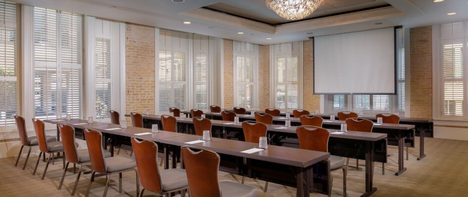 Meeting space set up with classroom style seating and projector