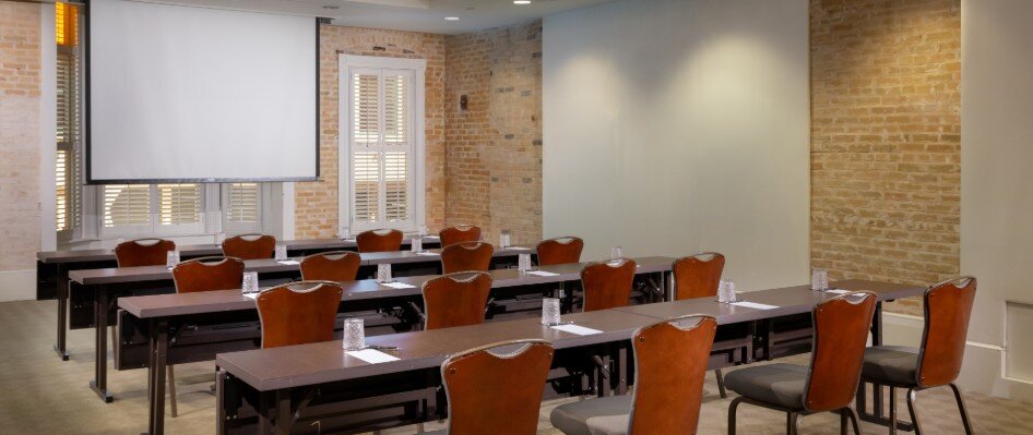 Meeting space set up with classroom style seating and projector