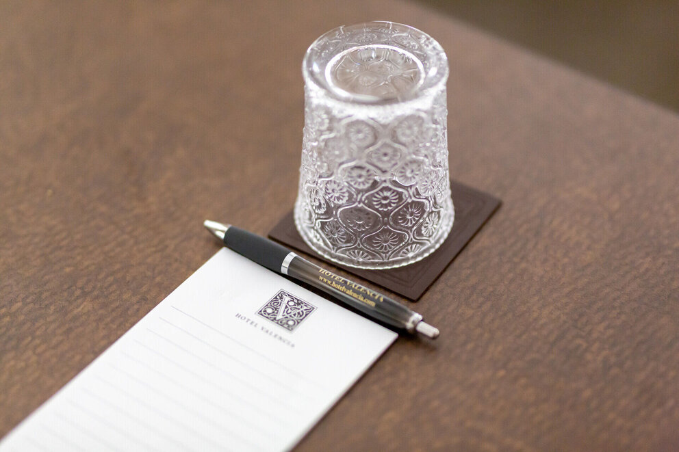 Close up of notepad, pen, and glass placed in meeting room