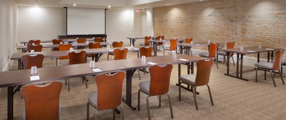 Meeting space set up with classroom style seating and projector