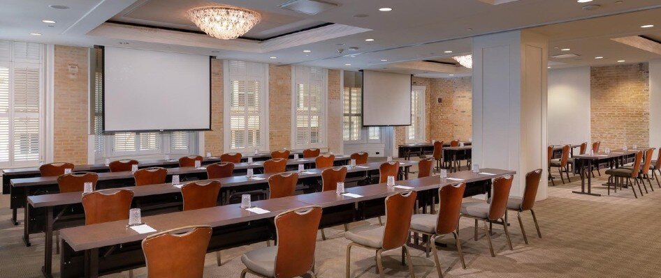 Meeting space set up with classroom style seating and projector