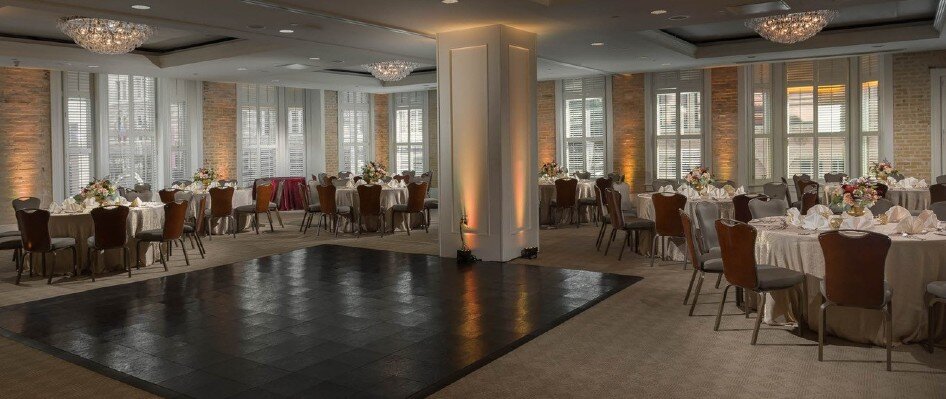 Dancefloor surrounded by round tables set for dinner