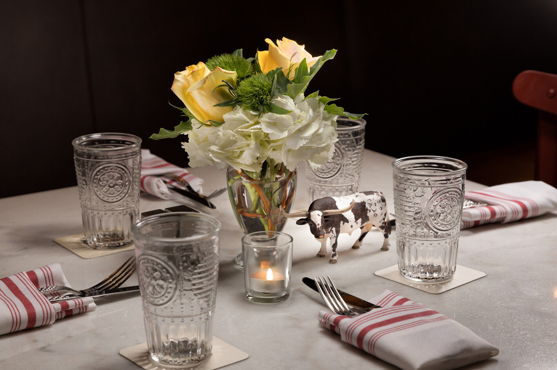 a table with glasses and a vase of flowers